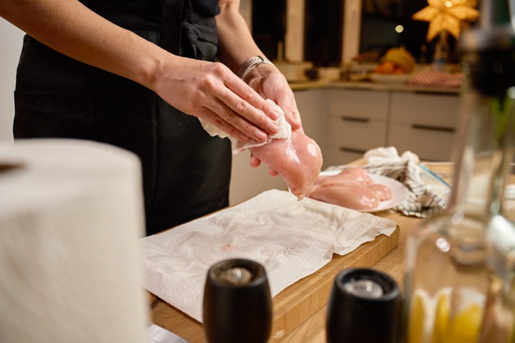 nő húsról papírtörlővel felitatja a nedvességet