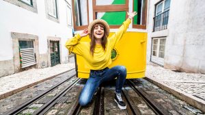 vidám lány portugáliában a sárga villamossal