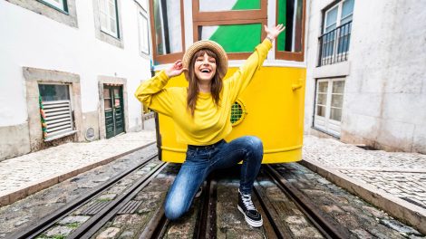 vidám lány portugáliában a sárga villamossal