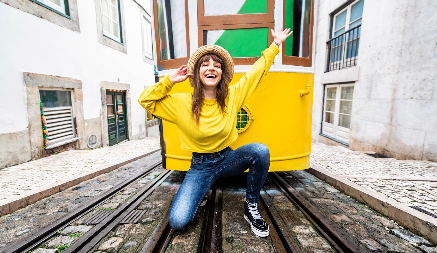 vidám lány portugáliában a sárga villamossal