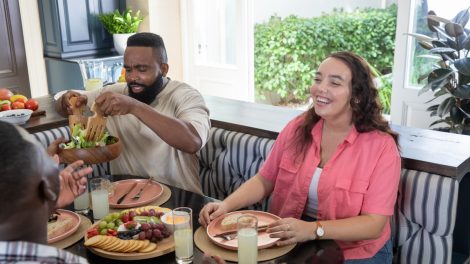 jó hangulatú baráti társaság sarokgarnitúrás konyhában uzsoonnázik