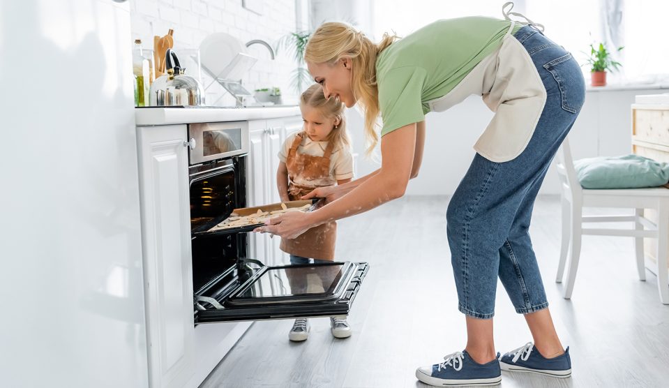 Édesanya a sütőbe teszi a sütemény a lányával