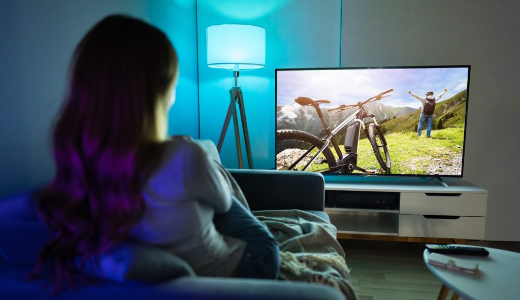 nő tévét néz otthon a nappaliban este