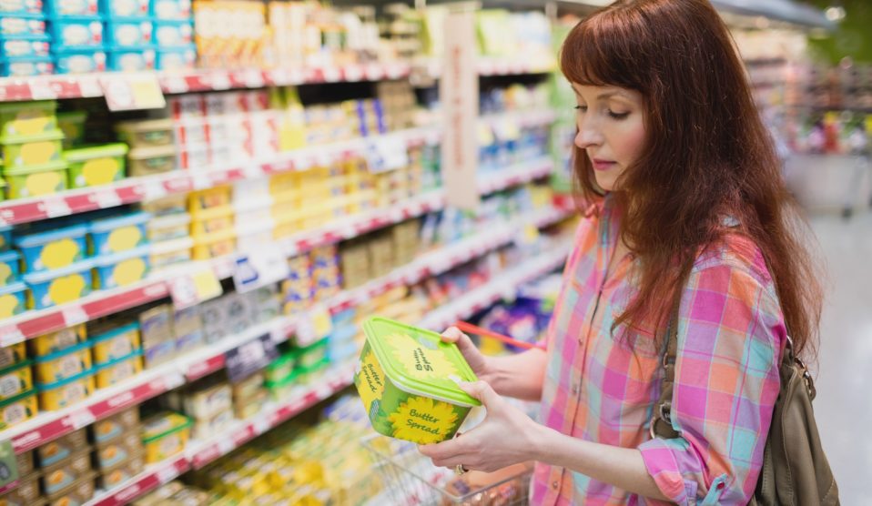 nő vajat vásárol a boltban