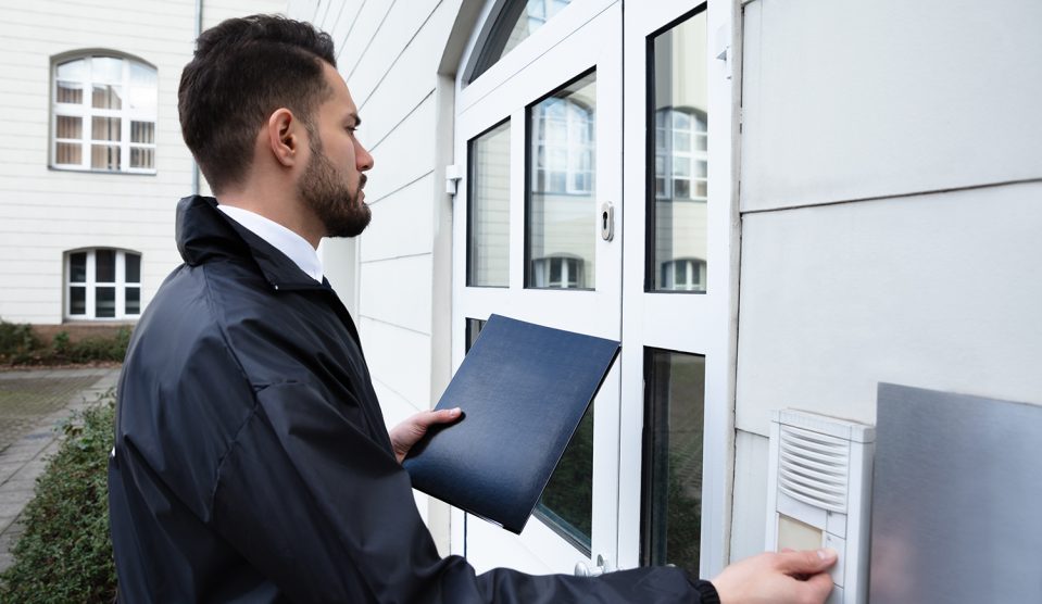 Férfi áll a ház bejáratánál és megnyomja a csengőt