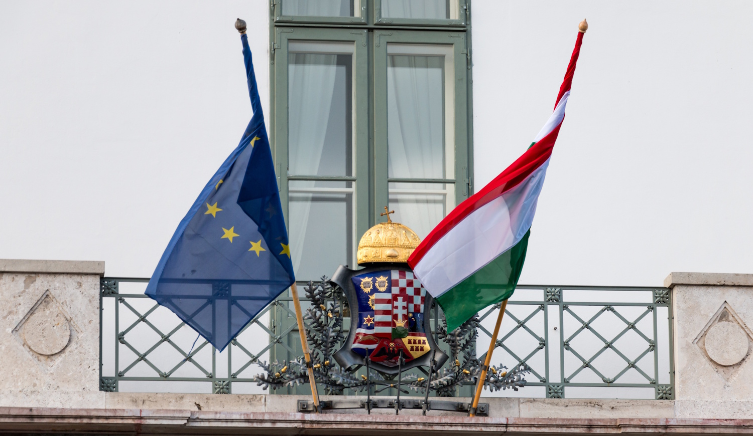 európai uniós és magyar zászló egy budapesti ház falán
