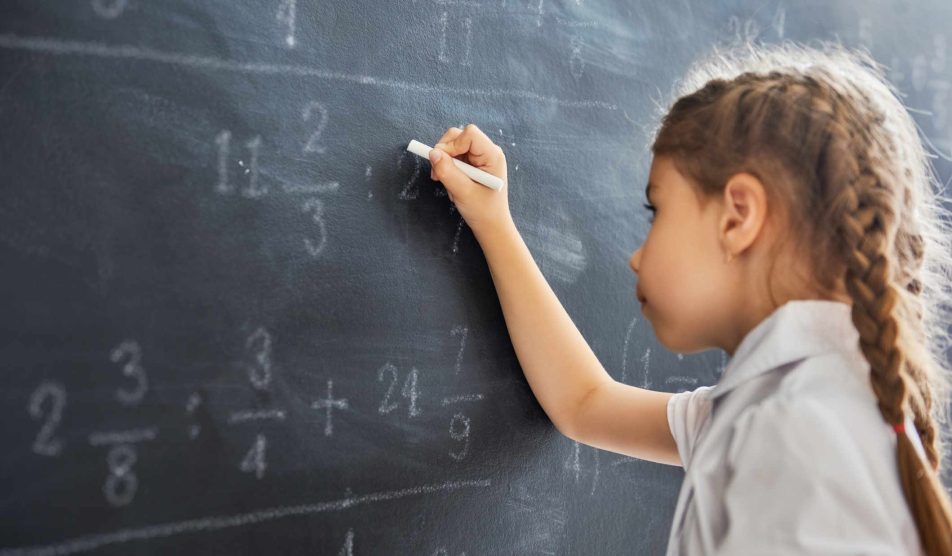Kislány matematikai egyenleteket old meg a táblán