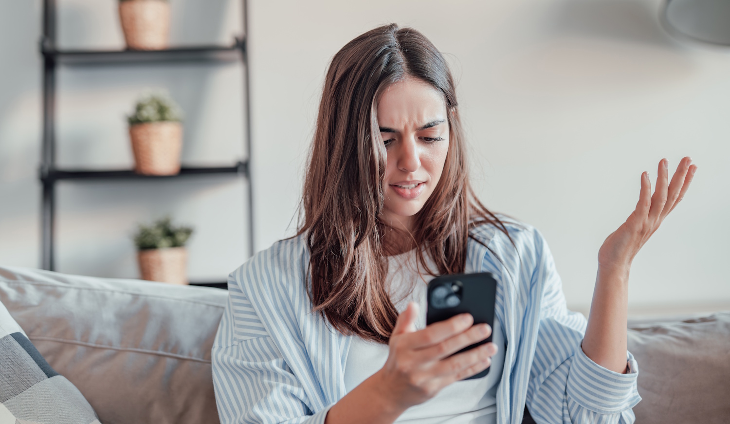 fiatal barna nő mérges a mobiltelefonjára