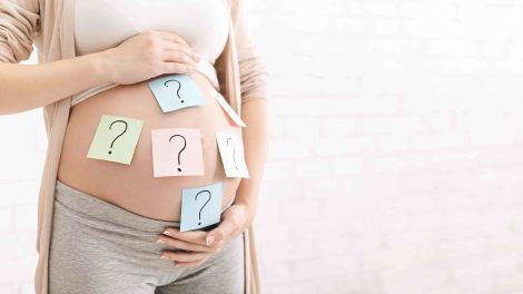 Várandós nő pocakján kérdőjeles postitek
