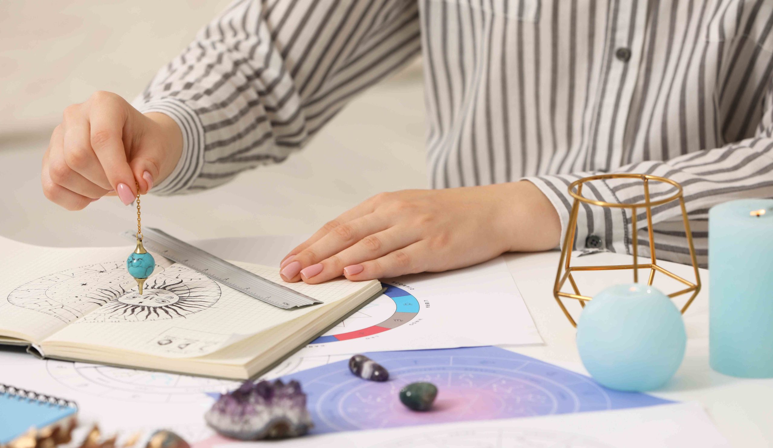 Asztrológus zodiákus kereket és ingát használ a sors előrejelzéséhez az asztalnál