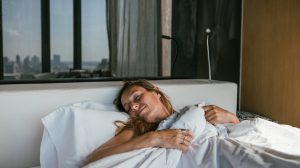 nő kánikulában alszik a hálószobában