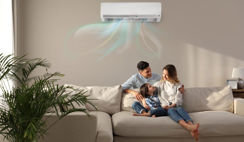 boldog család ül a klíma alatt a nappaliban