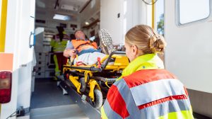 A mentősök hordágyra helyezik a sérült férfit a mentőautóban