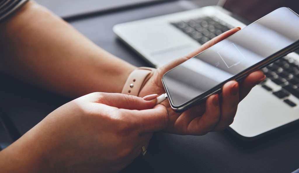 nő teszi fel a mobiltelefonját tölteni