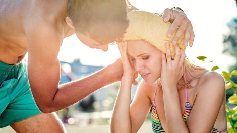 Férfi segít egy fiatal nőnek hőgutával a nyári melegben
