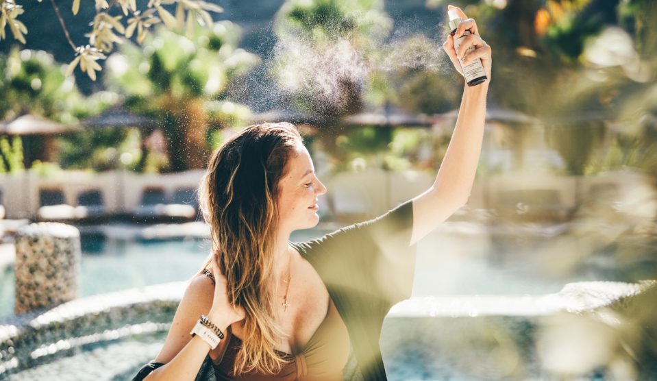 parfum-getty | Meglepetés nő nyáron parfümöt fúj magára
