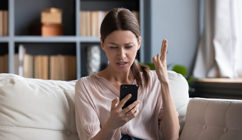 samsung-aksi | Meglepetés aggódó nő a kanapén a telefonját nézi