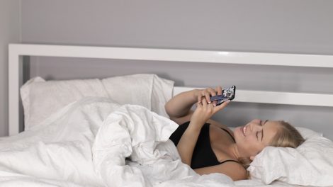 Egy lány telefonozik az ágyban