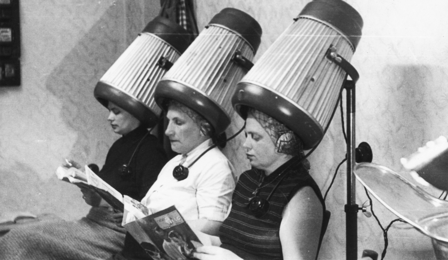 Nők ülnek a fodrásznál és újságot olvasnak