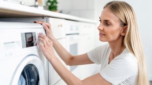 mosást 20 fokra állít be egy nő a mosógépen