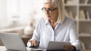 Nyugdíjas hölgy aggódva nézi a laptopját