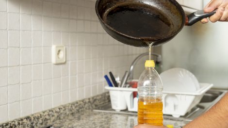 Elhasznált olajat önt egy múanyagüvegbe valaki