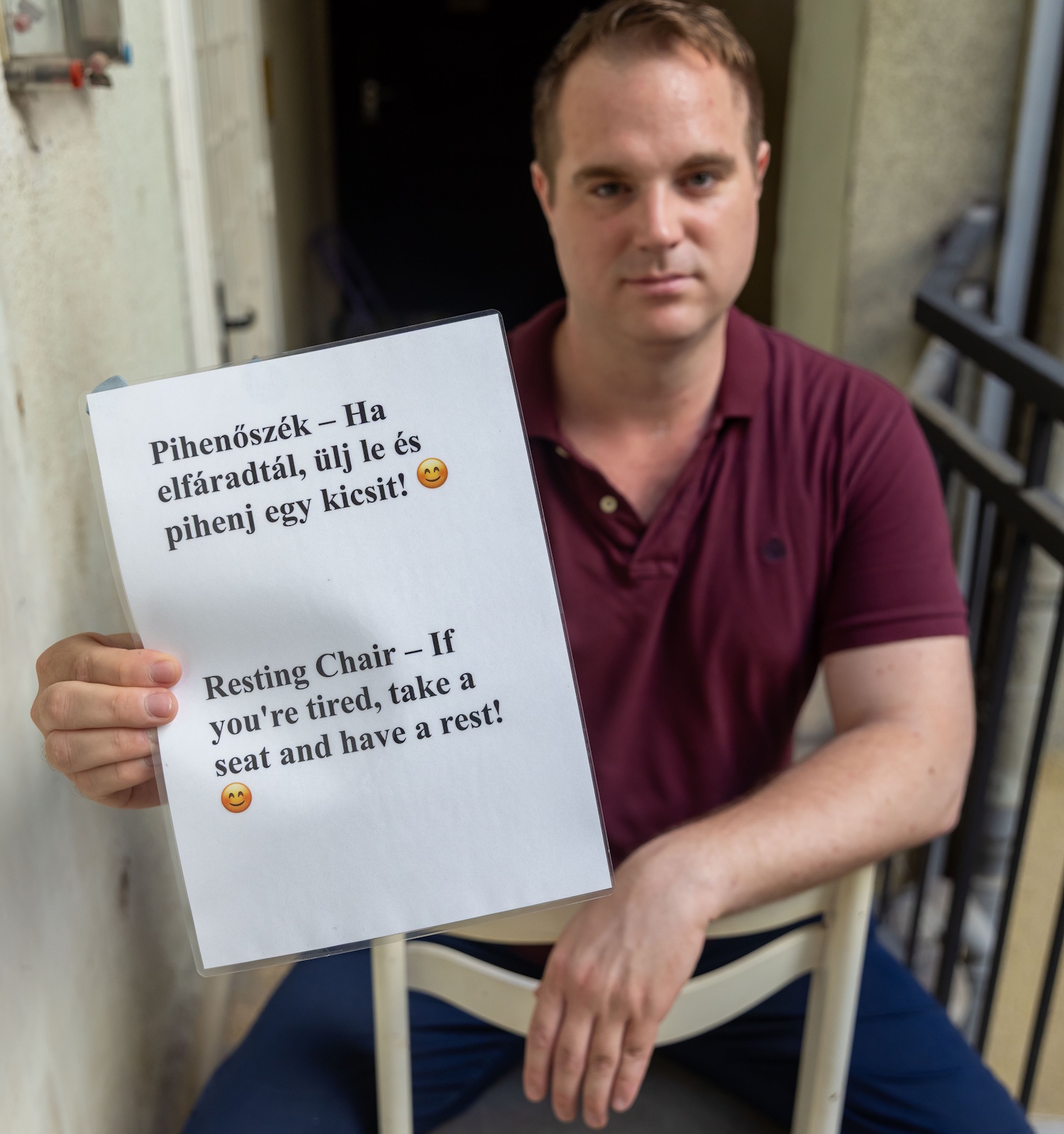 Taliga Norbert széket rak a bérház lépcsőházában