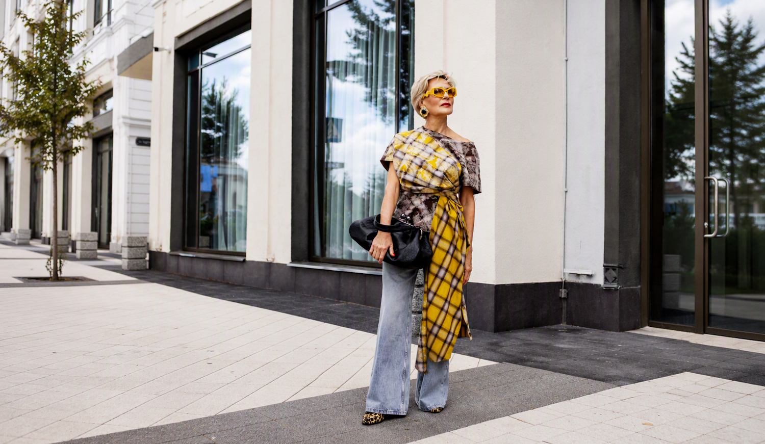 elegáns 60+-os nő trapéznadrágban az utcán