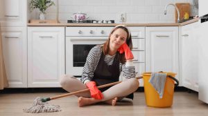 Nő ül a padlón felmosóval a kezében