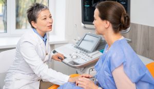 Nő szűrővizsgálaton a doktorral konzultál