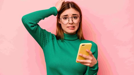Gondterhelt nő kezében a telefonjával