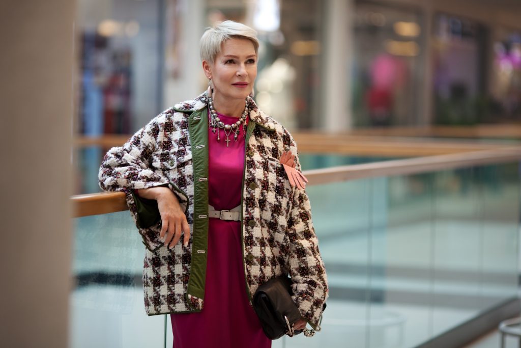 elegáns bordó ruhát viselő 60+-os nő divatos csinos