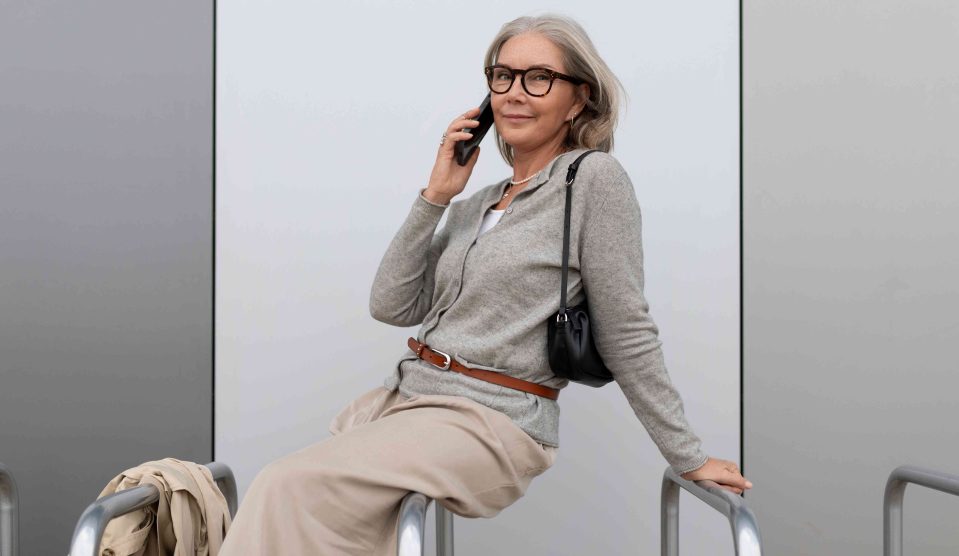 60+-os nő kardigánban telefonál