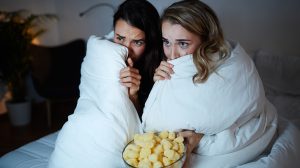 Két barátnő ijesztő filmet néz, a paplannal takarják az arcukat