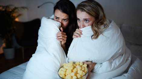 Két barátnő ijesztő filmet néz, a paplannal takarják az arcukat