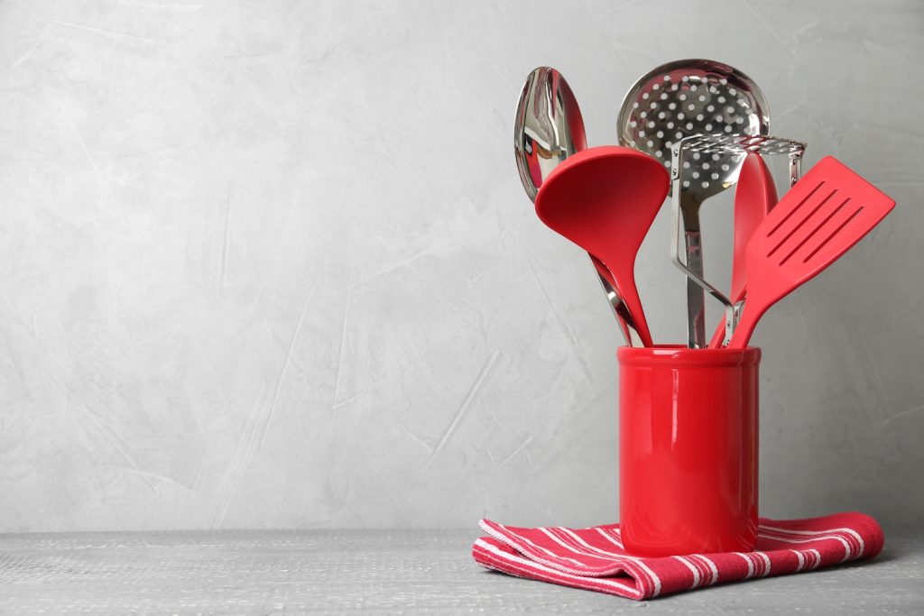 piros szilikon és fém spatulák, konyhai eszközök konyhapulton