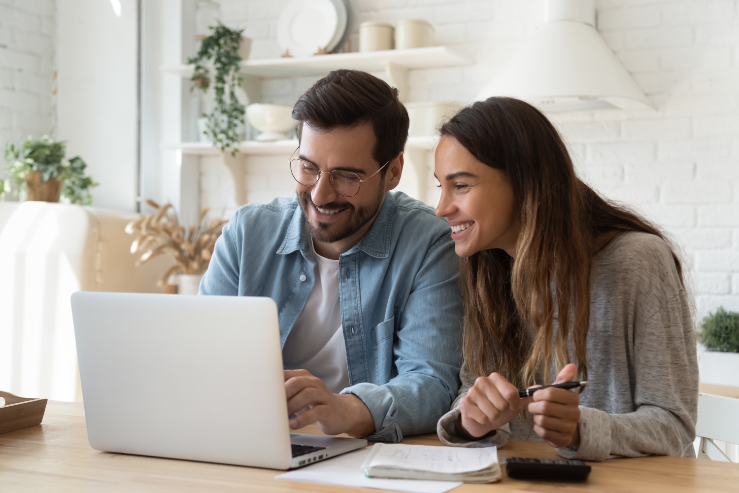 Egy fiatal pár mosolyogva nézi a laptopot