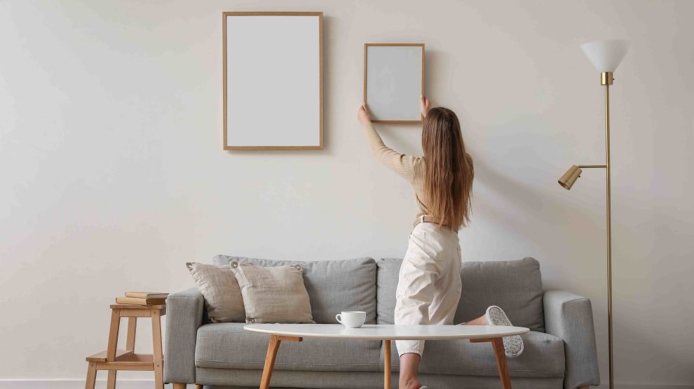 Nő képet tesz a falra
