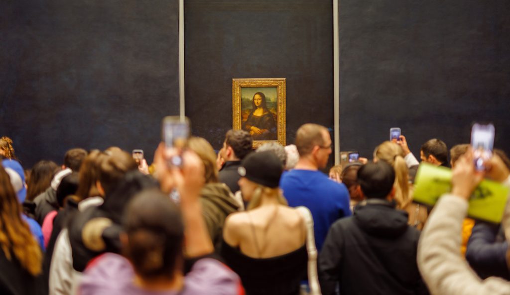 a mona lisát nézik emberek a múzeumban