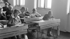 iskolás gyerekek iskolapadban iskolaköpenyben 1970-ben fekete fehér fotó illusztráció műveltségi kvízhez