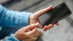 Nő töltőre teszi a telefonját