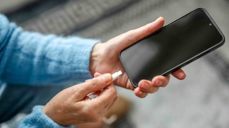 Nő töltőre teszi a telefonját