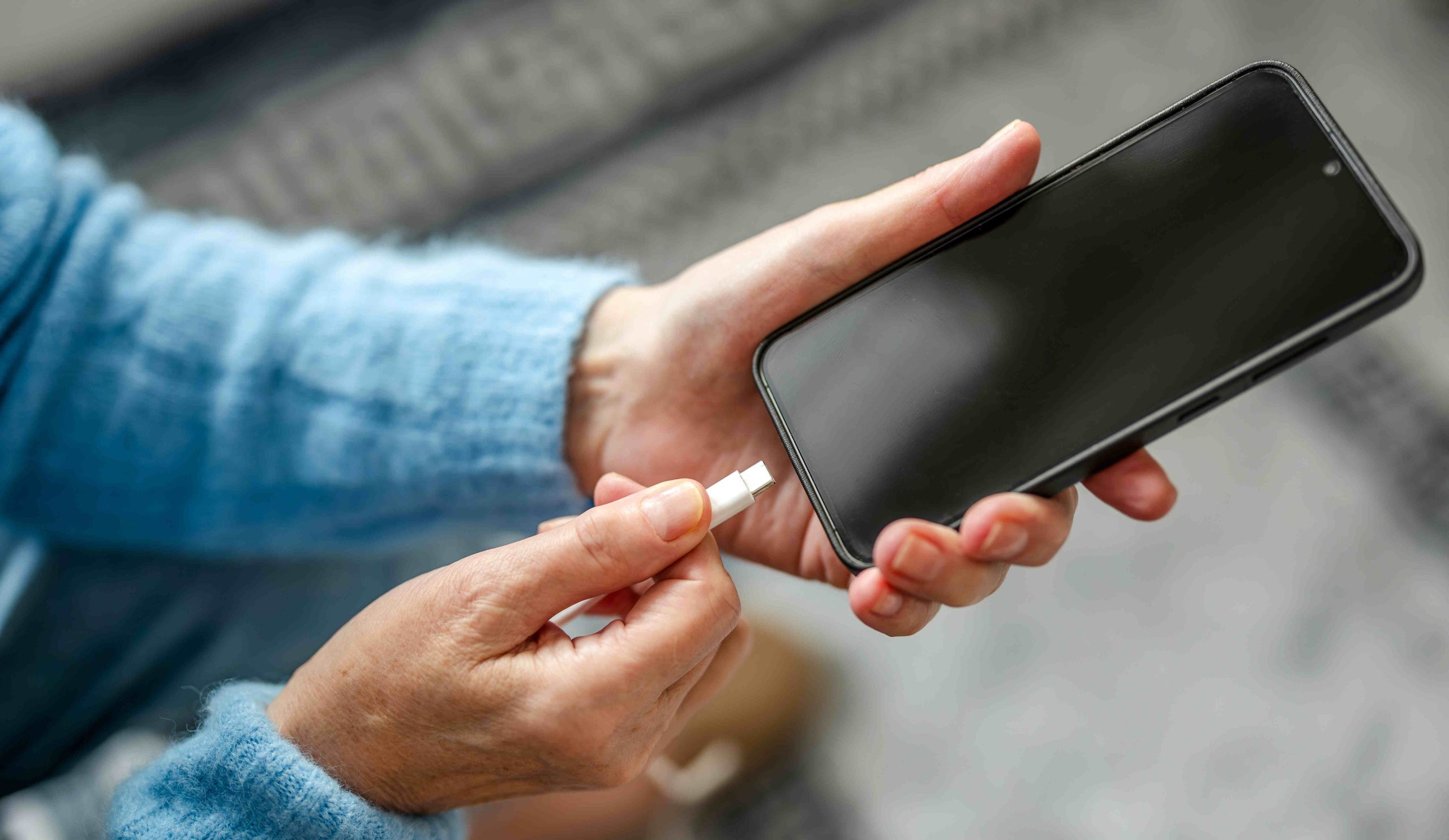 Nő töltőre teszi a telefonját